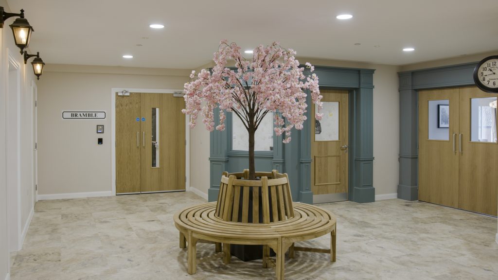 A round bench at Little Heath care home, with a blossom tree standing in the middle.
