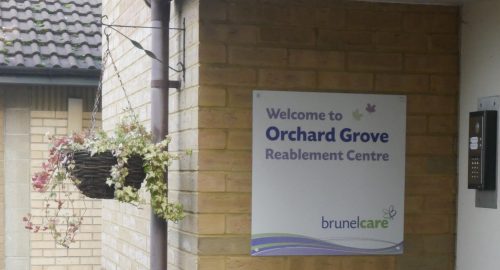A sign reading 'Welcome to Orchard Grove Reablement Centre'.