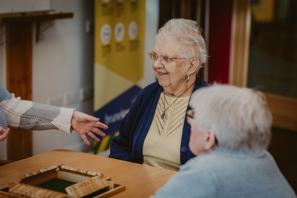 Extra care housing tenants playing board games.