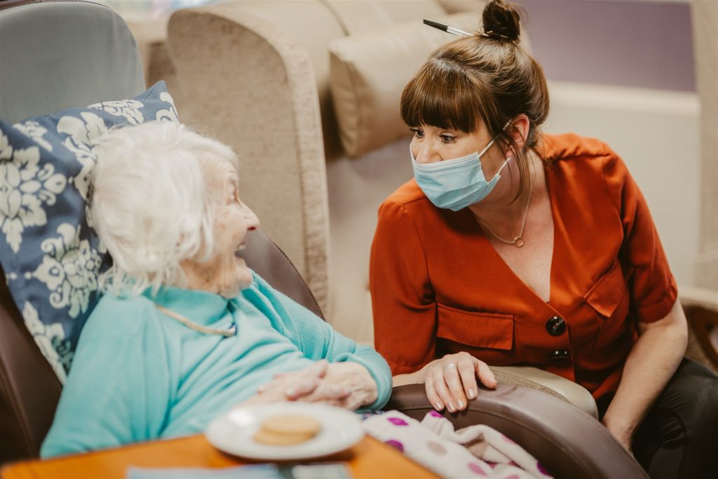 A carer and resident laughing at each other.