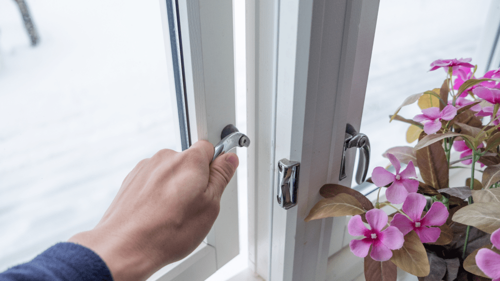 Close up of a hand opening a window.