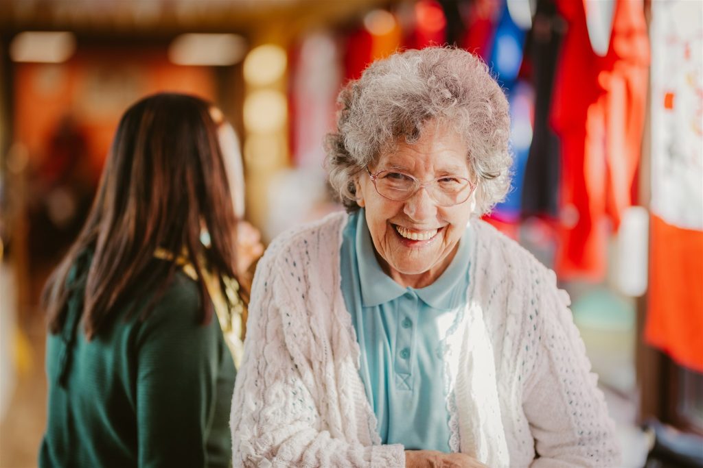 A care home resident smiles at the camera.